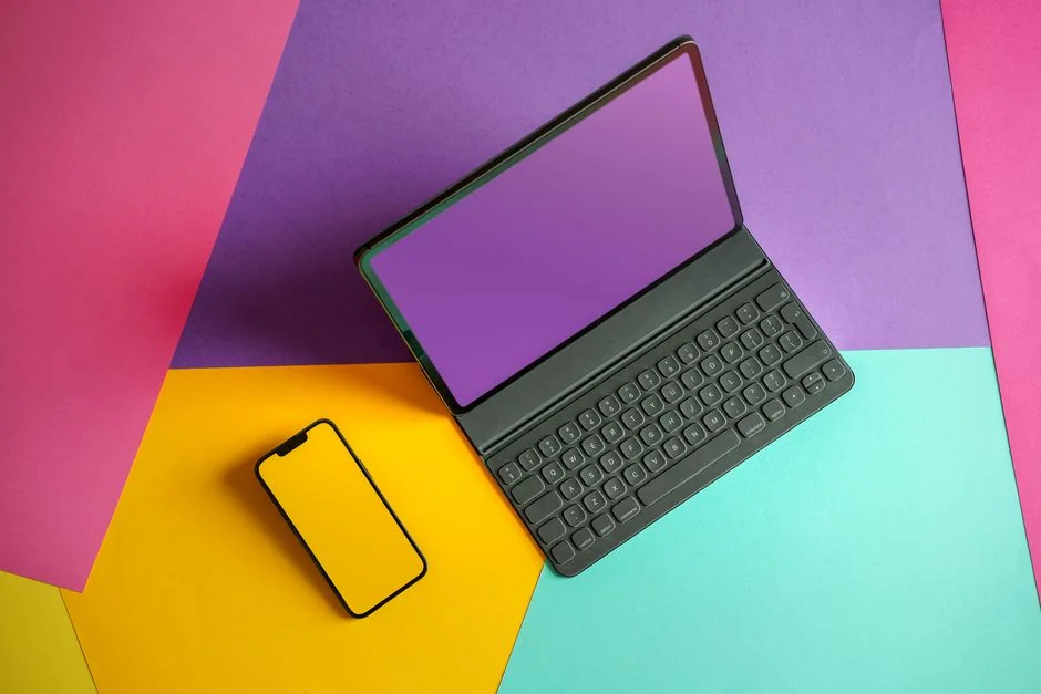 Uno spazio di lavoro contemporaneo che mostra un laptop, un tablet e smartphone, ideale per l’uso tecnologico e freelance.