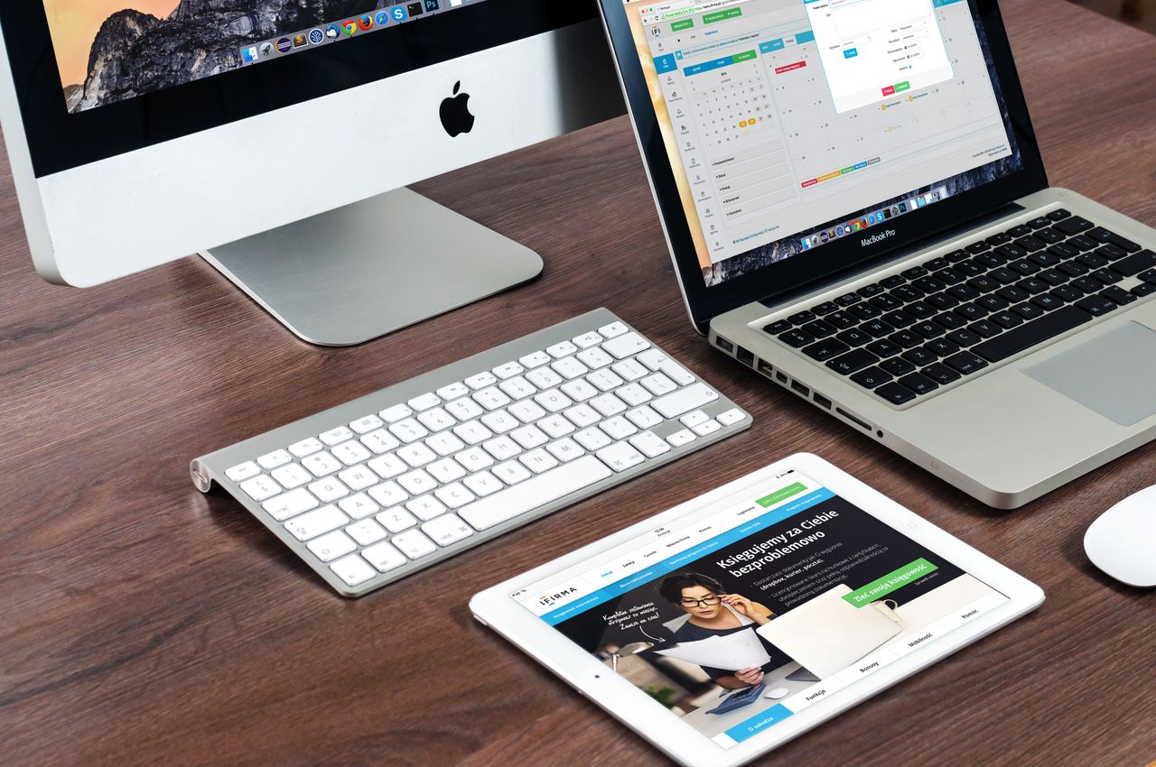 Un elegante allestimento da scrivania per ufficio con dispositivi Apple: iMac, MacBook e iPad.